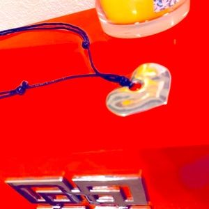 Polished heart pendant on adjustable two stranded black leather.